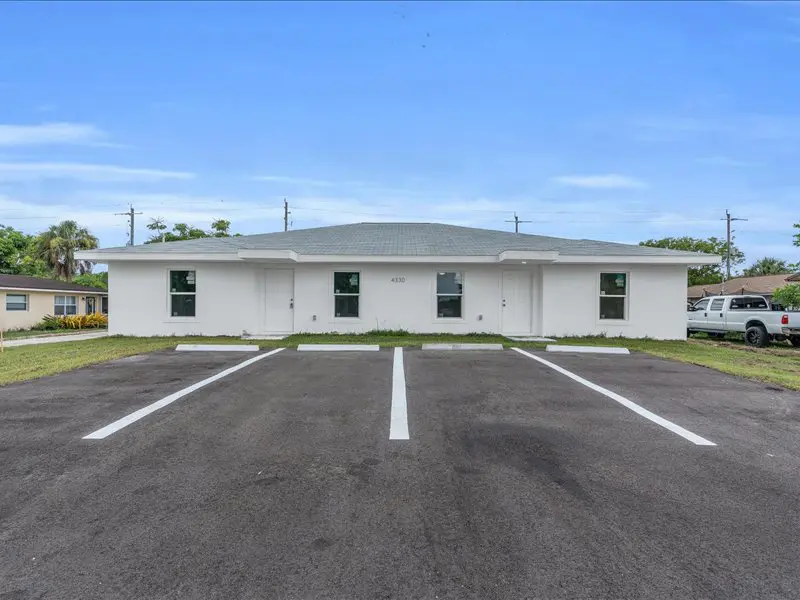 In Naples, FL, TN Capital Investments offers a white single-story duplex on Gulfstream Dr with two entrances and marked parking.
