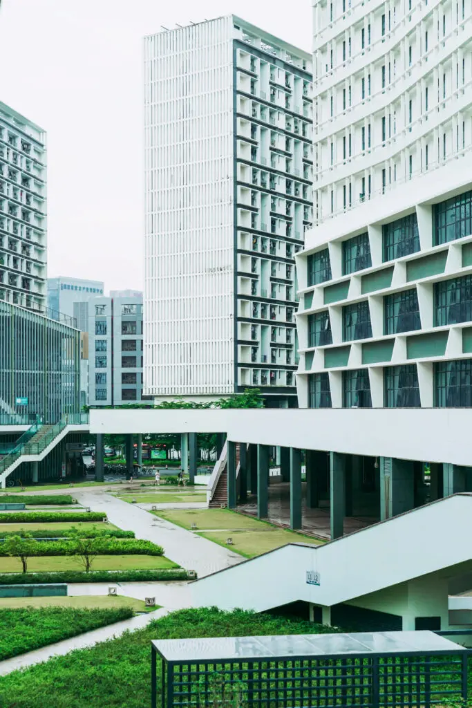 A landscaped courtyard with lawns and walkways is surrounded by TN Capital Investments’ modern buildings in Naples, FL.