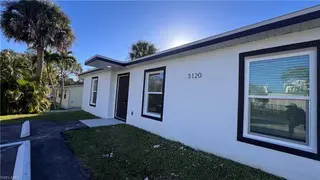 On Peters Avenue in Naples, FL, TN Capital Investments occupies a single-story white building labeled "3120" with black trim.